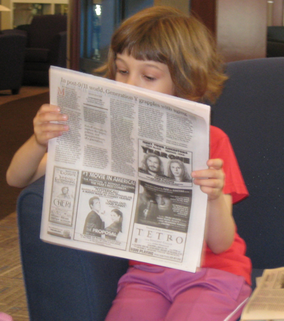 Caroline reading the comics at South Station